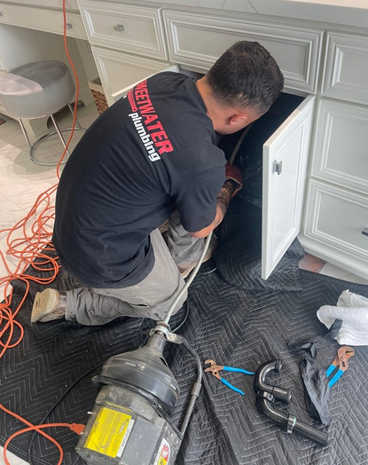 A plumber working on a backed-up drain.