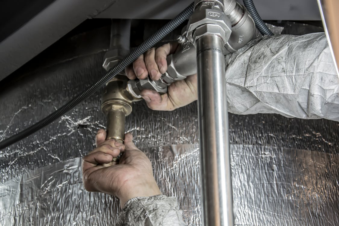 A plumber inspecting pipes for leaks