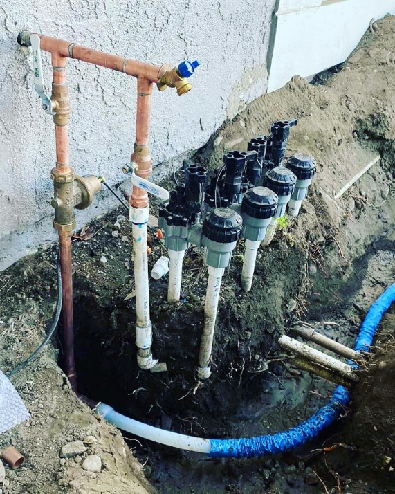Water leaking from a damaged pipe beneath a kitchen sink.