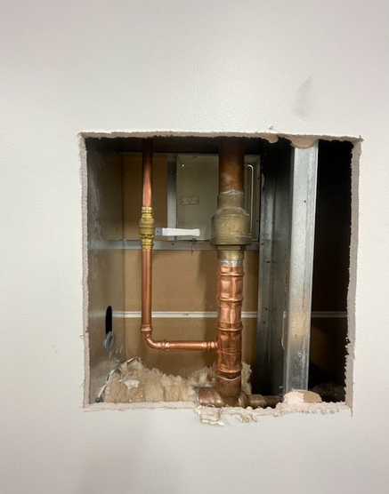 A plumber conducting a routine inspection of household plumbing.