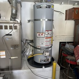 A plumber inspecting a water heater