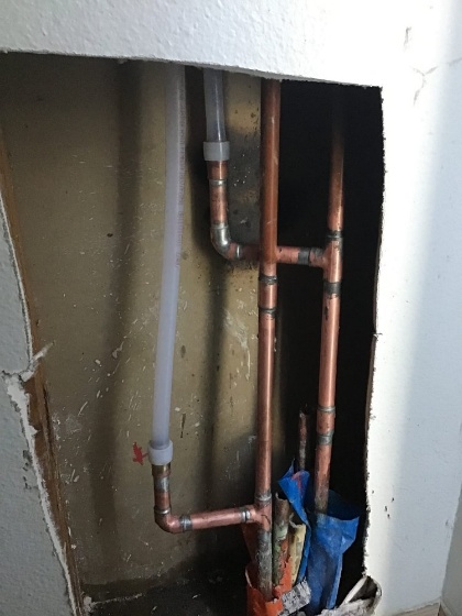 A close-up of a smart leak detection device installed on a pipe.