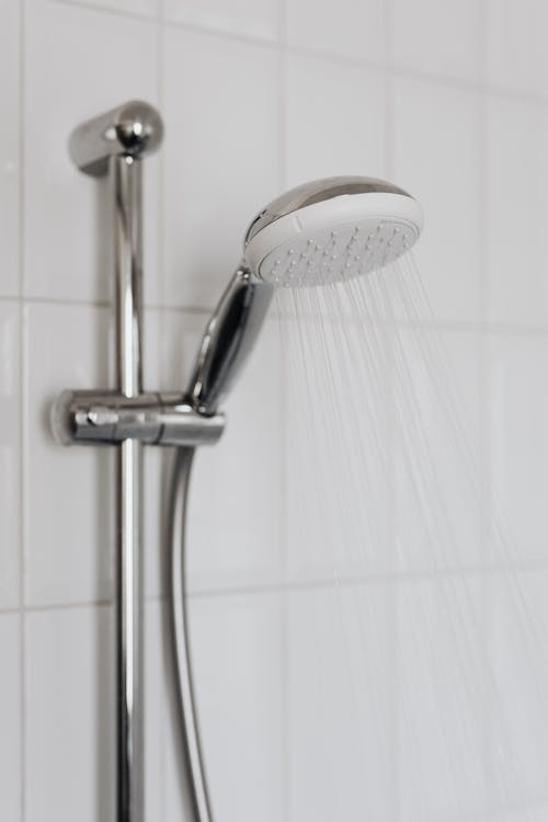 Hot water flowing from a modern shower head, illustrating the benefits of a properly installed and maintained water heater.