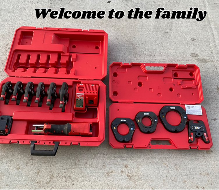 Set of plumbing tools laid out on a workbench, including wrench, tape, and fittings.