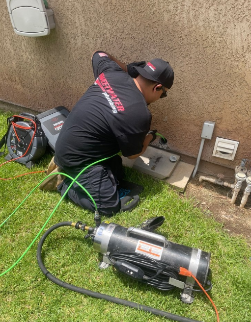 A plumber clearing a drain.