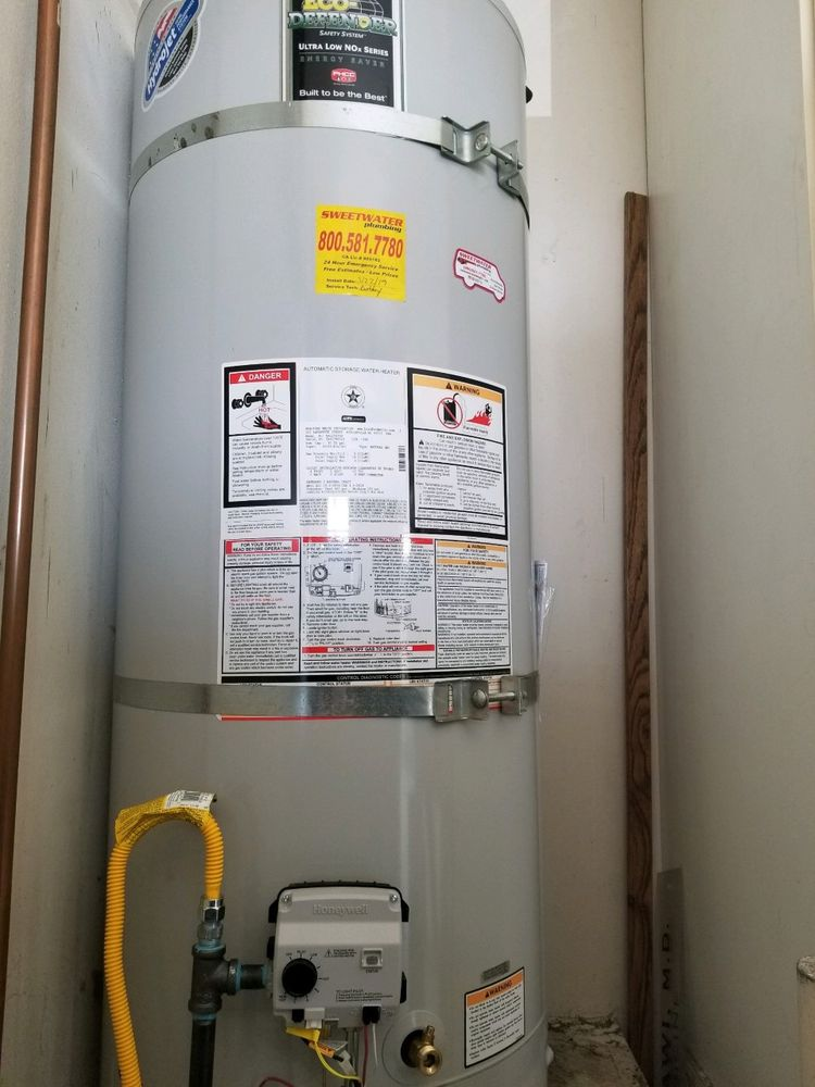 A plumber performing water heater repair services in a residential home.