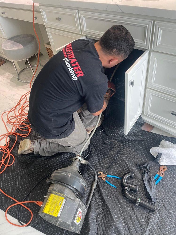 A plumber doing getting drain cleaning in Riverside