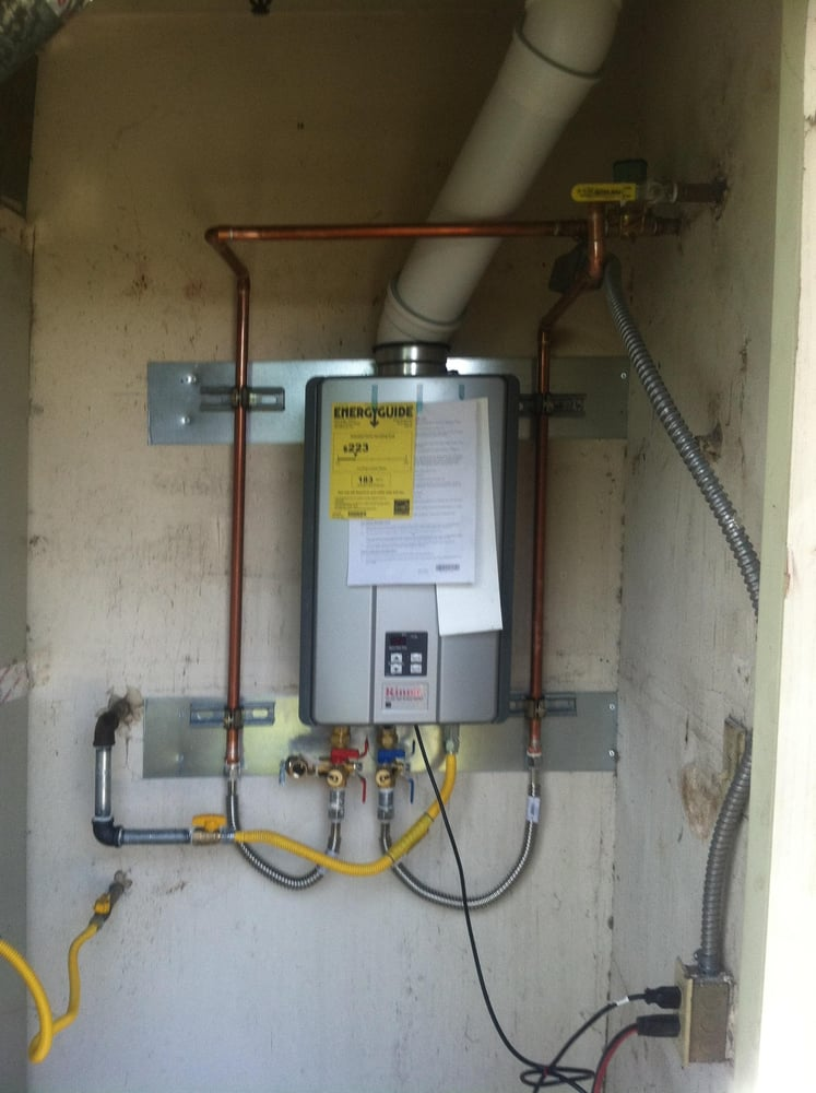 A wall-mounted tankless water heater in a modern laundry room.