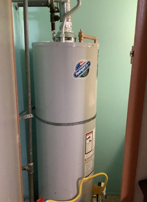 A professional technician installing a water heater in Chino.
