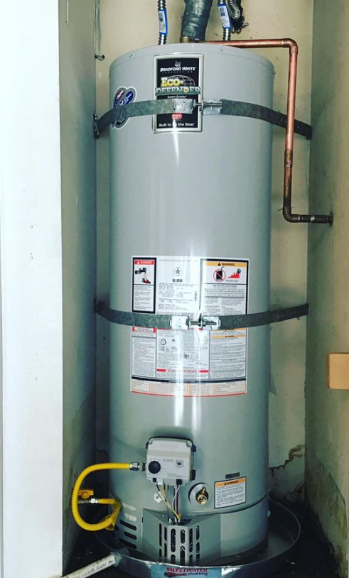 A traditional tank water heater installed in a home utility room.