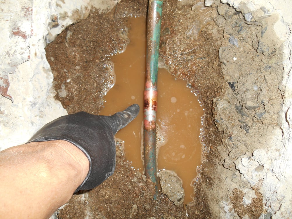 Water leak under a bathroom sink with visible pooling.