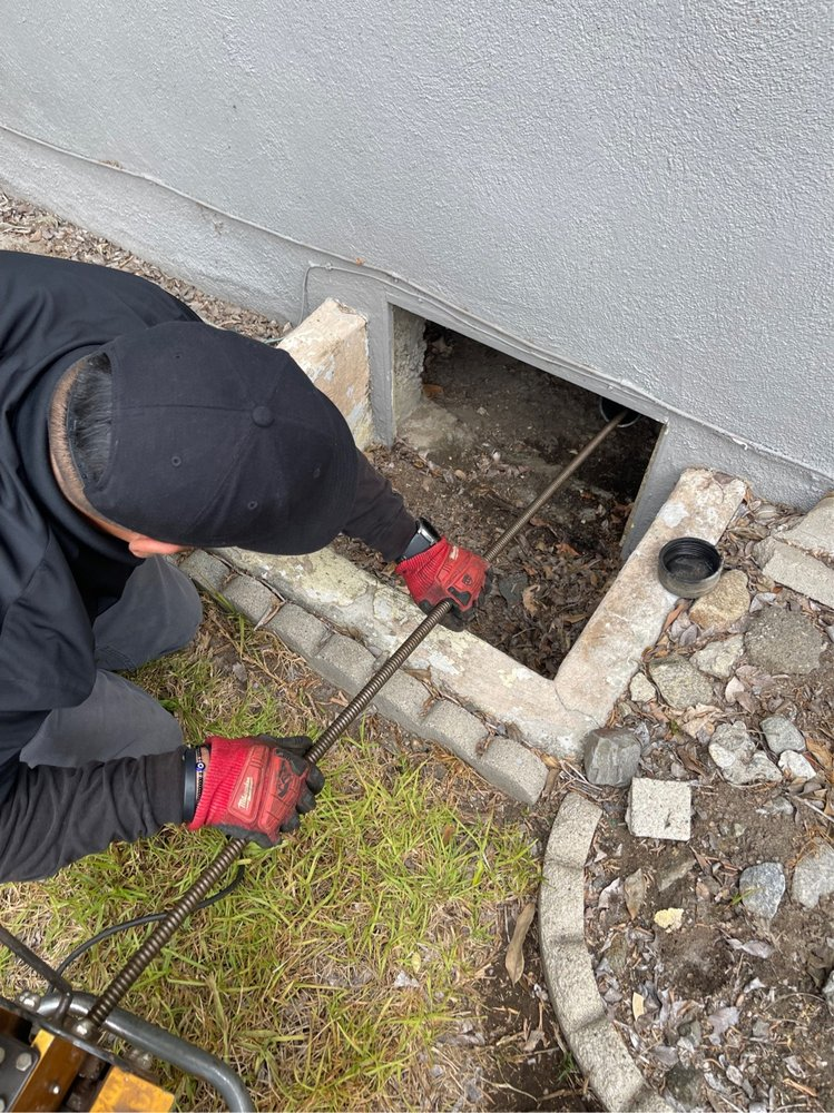 A professional plumber performing drain cleaning services.