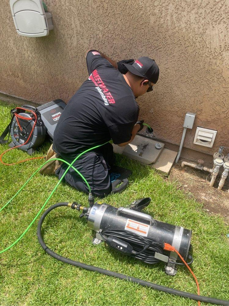 A plumber cleaning a drain through hydro-jetting.