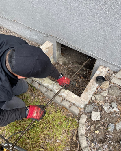 A plumber clearing a drain.