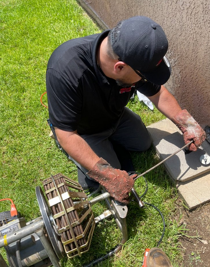 An emergency plumber clearing drains.