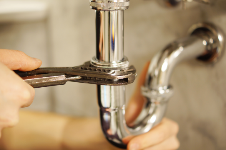 A plumber repairing a plumbing fixture.