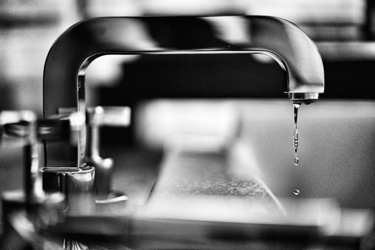Water dripping from a faucet, signaling the need for timely plumbing repair by Ontario plumbers.