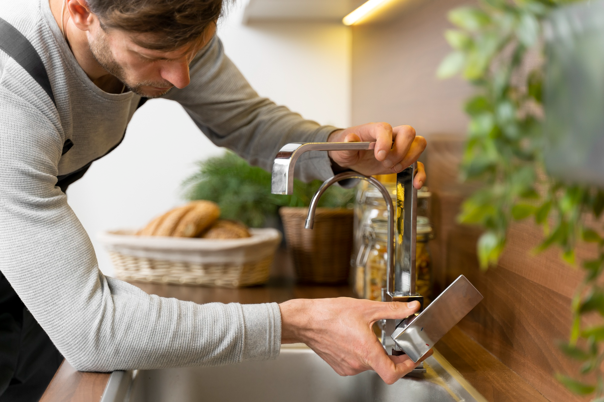 Professional plumber adjusting a faucet to fix inconsistent water pressure.