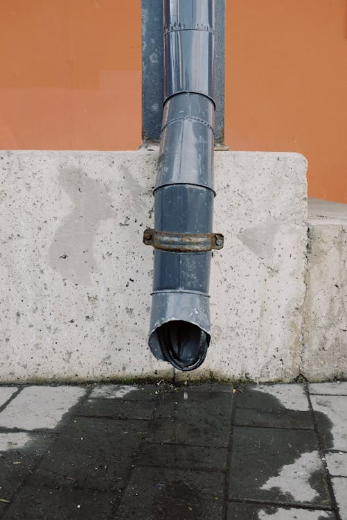 Outdoor house drain pipe installed on a concrete wall