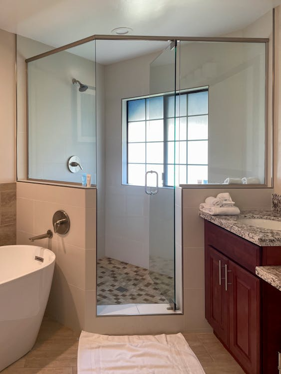 Modern bathroom with a shower cabin and a towel on tiled floor