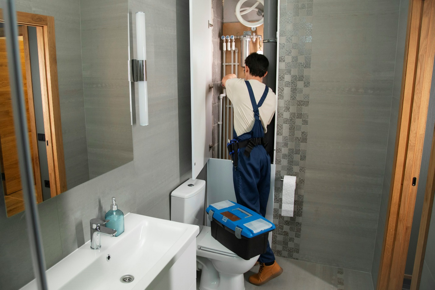 Technician with tools installing a new tankless water heater unit.