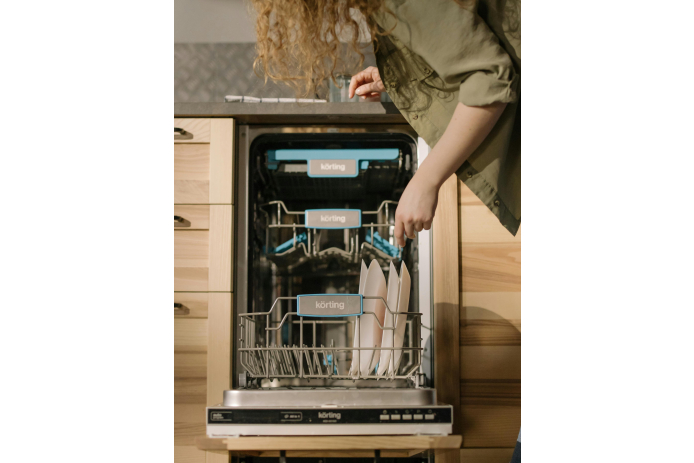 Person using a dishwasher to clean plates.