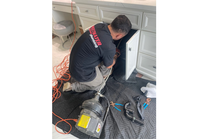 A plumber clearing a drain.